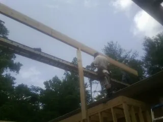 Carpenter setting a ridge beam over a new addition frame — Ice Dam Removal by Roofing Brothers in Davy